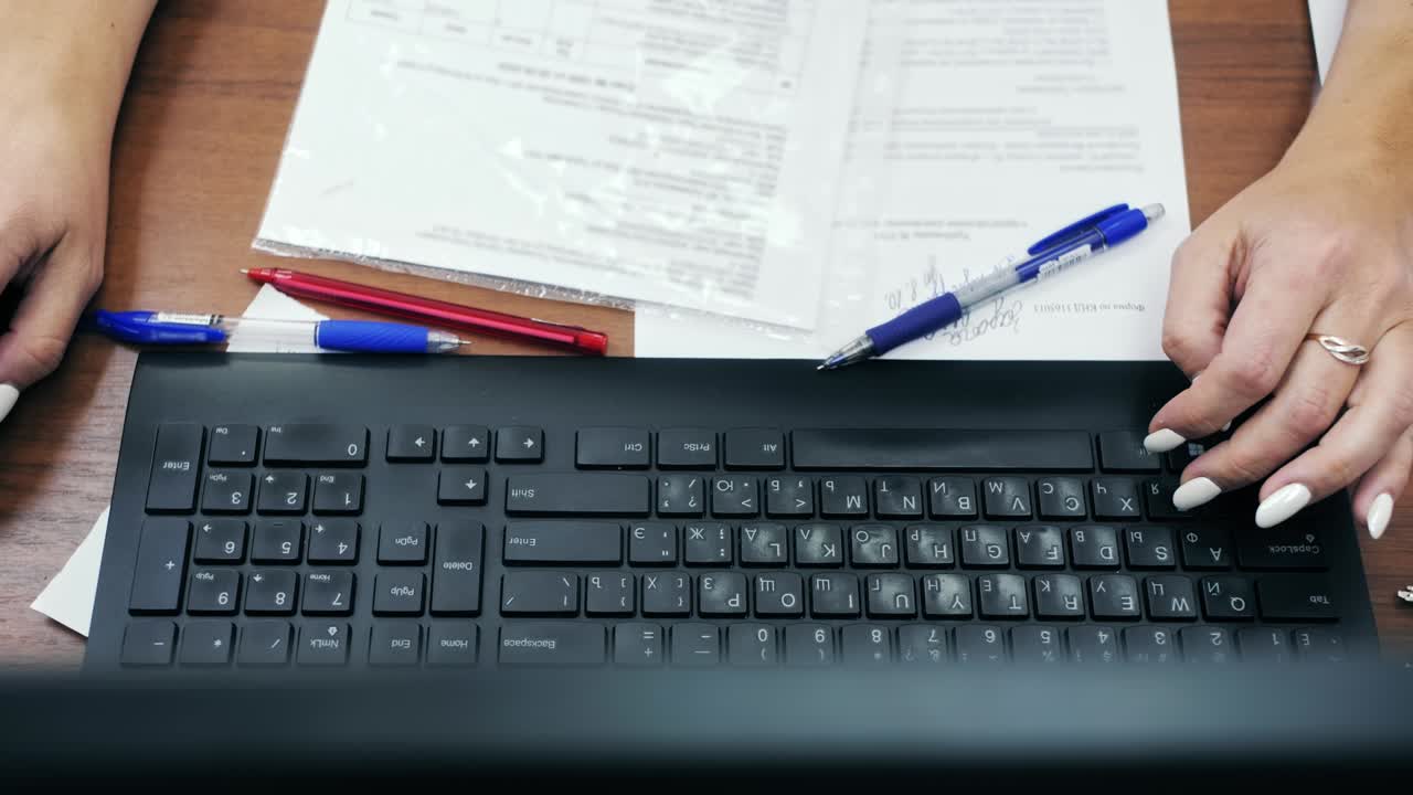 vista superior de primer plano de las manos de un empleado de oficina escribiendo en el teclado de la computadora