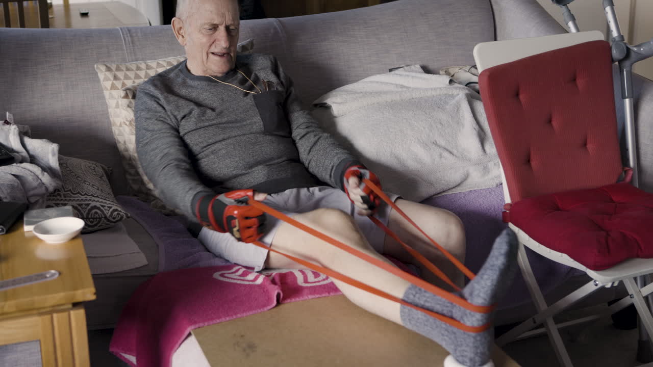 Senior man exercising with resistance band at home
