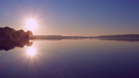 bright sunrise shining over the hauraki gulf with beautiful reflections on the water in auckland, new zealand