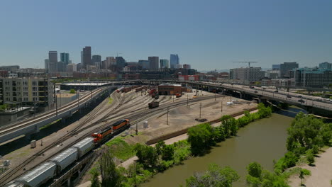 Downtown-Denver-Coors-field-Colorado-Rockies-baseball-stadium-Rocky-Mountain-landscape-South-Platte-River-aerial-drone-cinematic-foothills-Colorado-cars-traffic-Amtrak-train-spring-summer-down-motion