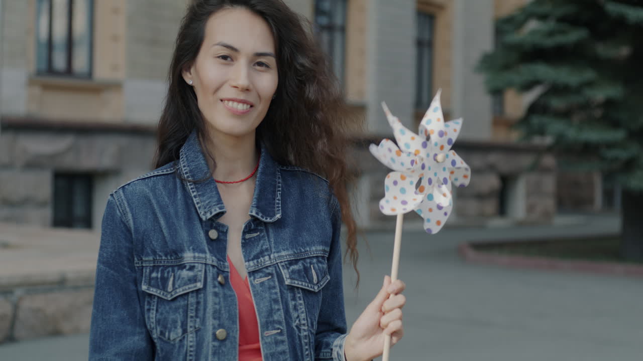 Woman Smiling Outdoors with a Pinwheel
