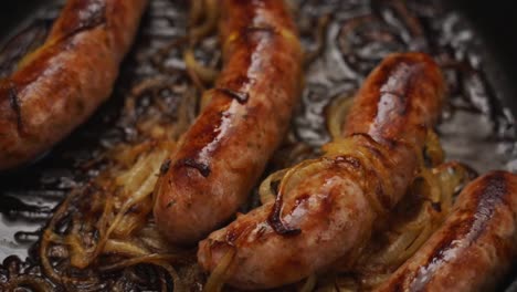 fried sausages in pan with onion