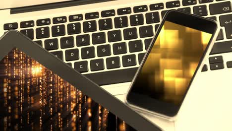 animation of gold glowing details displayed on electronic devices and computer keyboard