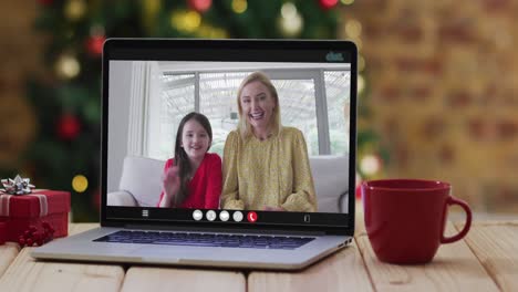 Feliz-Madre-E-Hija-En-Videollamada-En-Computadora-Portátil,-Con-Adornos-Navideños-Y-árbol