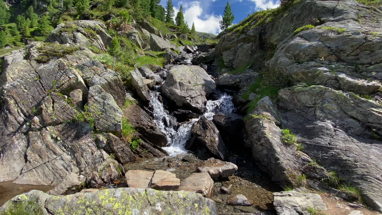 pequeño río en los alpes entre rocas y con agua burbujeante, fluyendo desde una montaña en austria