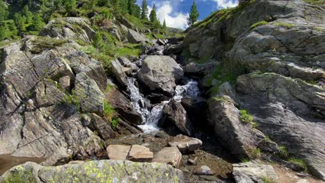 small river in the alps between rocks and with bubbling water, flowing down from a mountain in austria