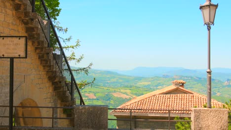 Pan-shot-over-beautiful-hilly-terrain-surrounded-by-historic-architecture-in-San-Marino,-northern-Italy-at-daytime