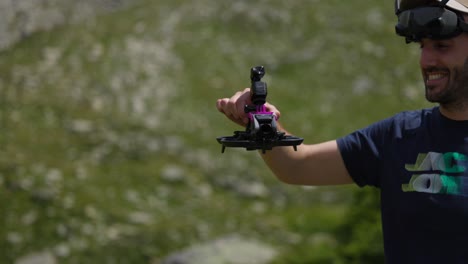 piloto de avión no tripulado sonriente sosteniendo un quadcopter avata con cámara de acción osmo montada en la parte superior con paisaje de montaña en el fondo