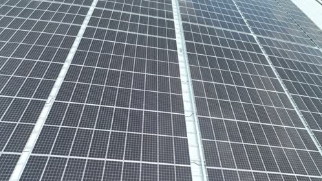 closeup of surface of blue photovoltaic solar panels mounted on building roof for producing clean ecological electricity. production of renewable energy concept