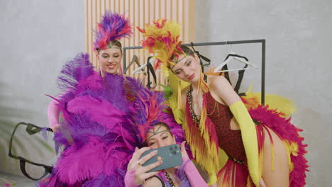 trois jolies danseuses prenant des photos d'elles-mêmes avec des tenues colorées