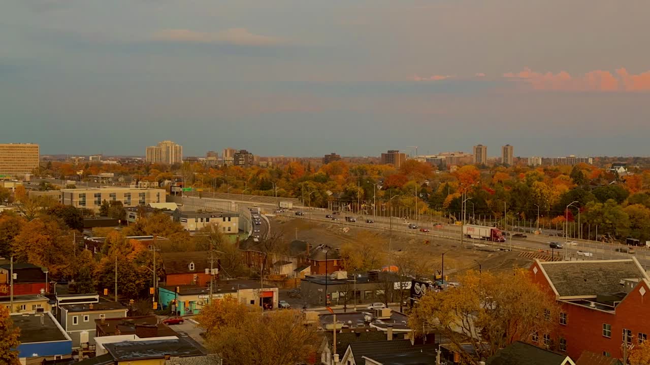 Late afternoon to early evening time lapse showing fast Ottawa rush hour traffic, fall tree canopy, and neighbourhood houses, exterior high wide shot