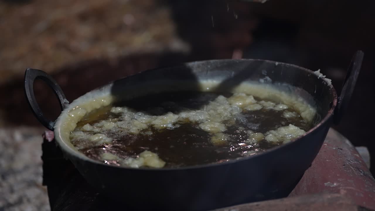 Cucina primitiva sul fuoco all'aperto in una pentola di villaggio, preparazione di latticini e cibi antichi
