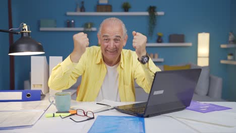 Home-office-worker-old-man-experiencing-joy-looking-at-camera.