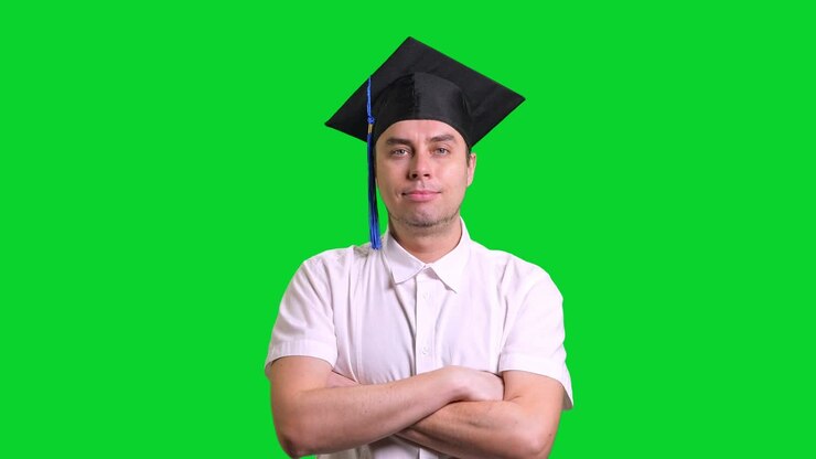 Giovane uomo laureato sorridente con cappello di laurea nero