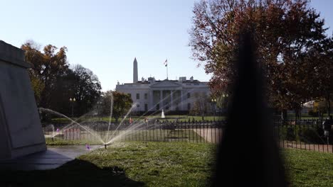 establishing shot the white house in distance, view of watering system on beautiful garden