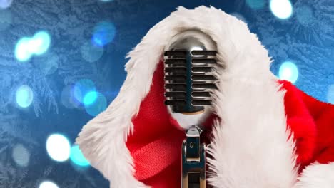 Santa-hat-over-microphone-against-spots-of-light-against-blue-background