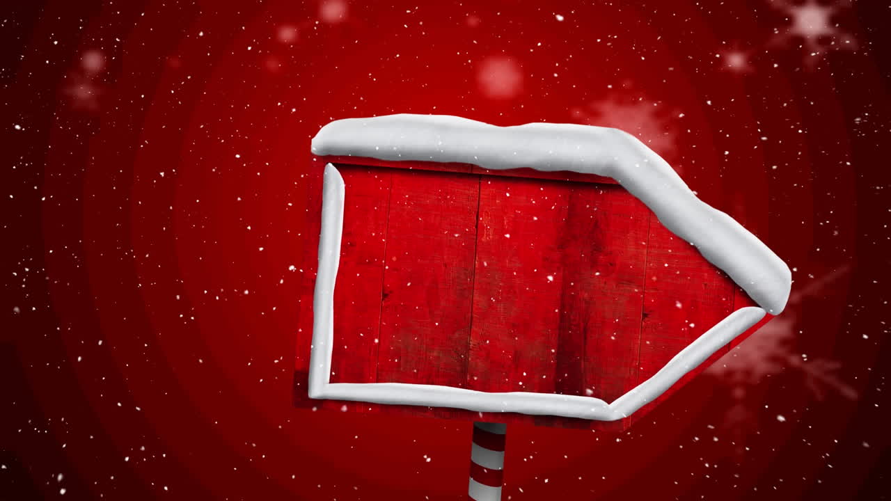 nieve cayendo sobre un poste de señal de madera roja contra un fondo rojo