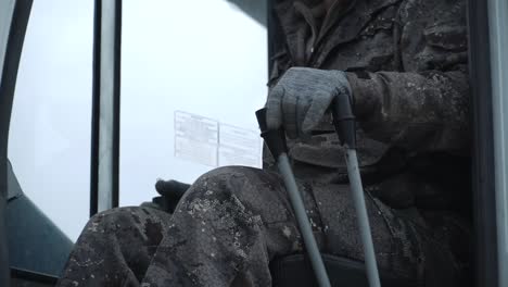 person in camouflage sitting in vehicle cabin