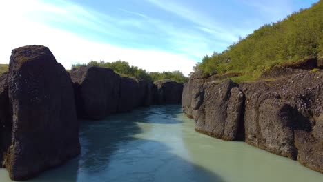 Aerial-drone-moving-shot-of-silent-water-flowing-in-between-the-rocks