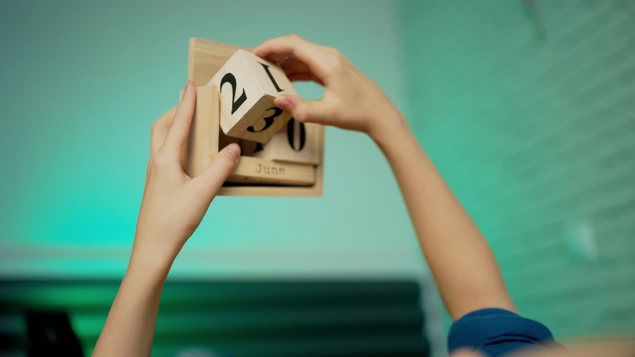 Boy changing wooden calendar block on 4th of July American Independence day