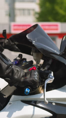 skilled biker in uniform with pretty girlfriend rides contemporary motorcycle together along large city street on sunny day slow motion closeup
