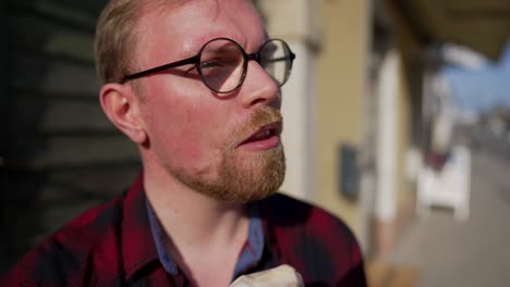 primer plano de mano del hombre comiendo helado en cono en día soleado