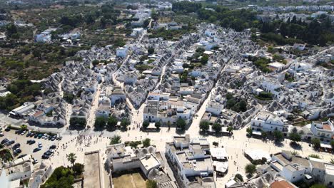 Aerial-drone-wide-shot-pushing-to-beautiful-town-Alberobello,-Italy