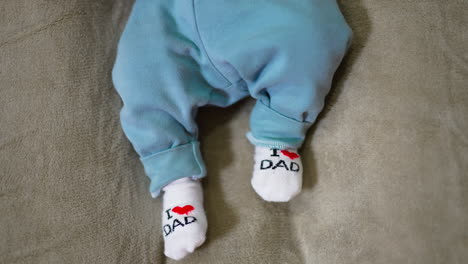 adorable little feet of a toddler moving them constantly. baby feet in cute white socks. grey background.
