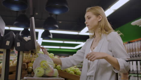 middle-aged woman weighs a bag of apples in the supermarket