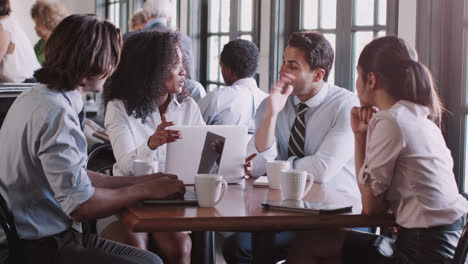 business team having informal meeting around table in coffee shop