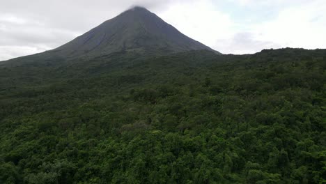 aerial view moving forward shot, above the rain forest of costa rica, scenic view arena volcano in the background