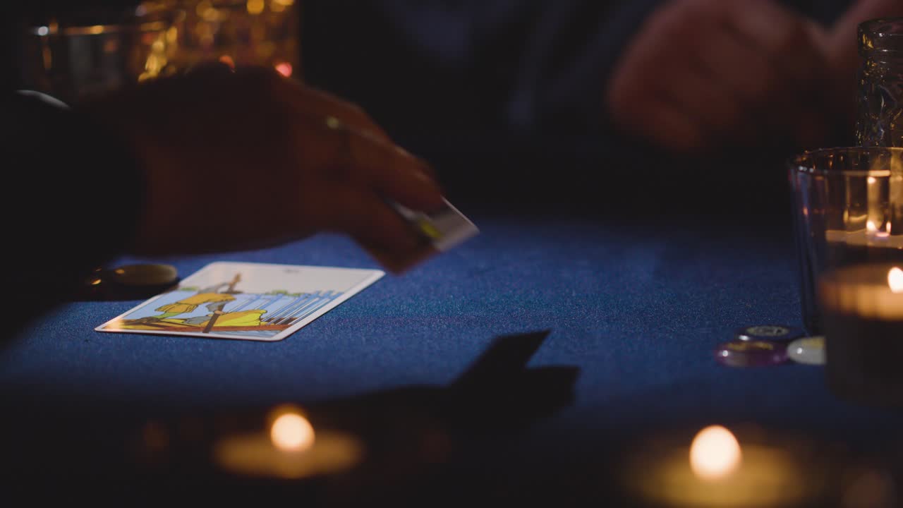 primer plano de una mujer dando lectura de cartas de tarot a un hombre en la mesa a la luz de las velas 8