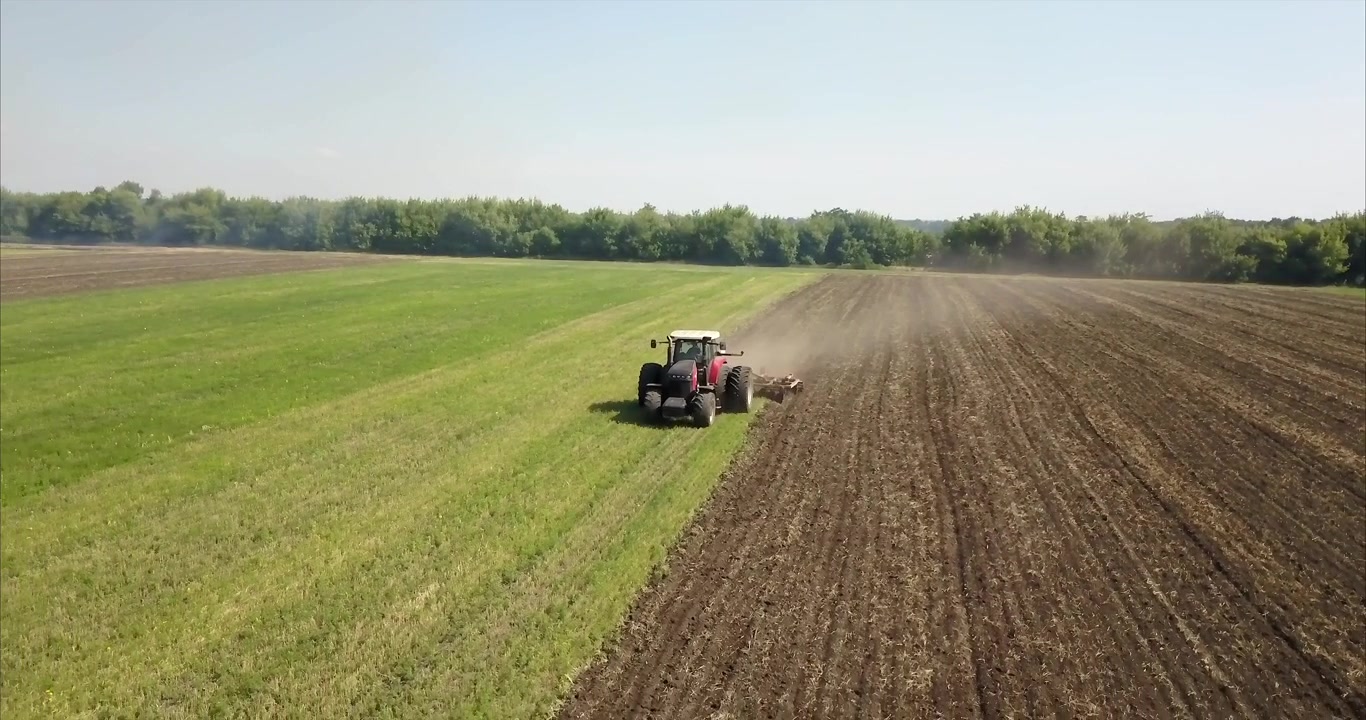 Ripresa con drone: trattore che coltiva la terra nera in Ucraina -- drone 4k