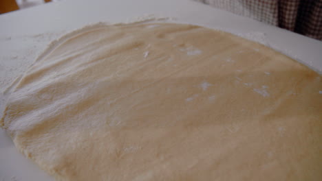 young female roll out dough for a cake in the kitchen at home