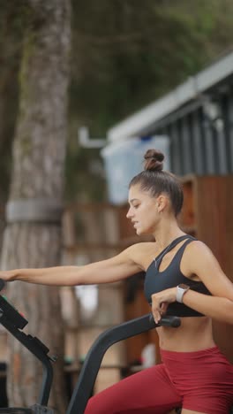 young woman exercising outdoors on a fitness machine