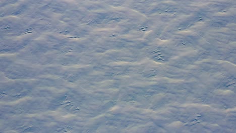 aérien de haut en bas volant en avant au-dessus des motifs dans la neige fraîche