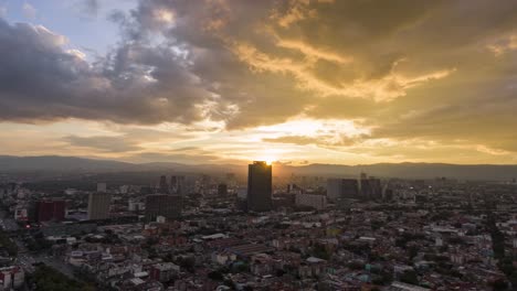 hyperlapse or drone lapse top view flies over mexico’s financial district with skyscrapers. business and industrial center of mexico city on a dramatic cloudy day during the golden hour before sunset.