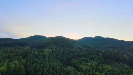 Vista-Aérea-Sobre-Exuberantes-Bosques-Verdes-Y-Colinas-En-Las-Montañas-De-Los-Cárpatos,-Durante-La-Puesta-De-Sol,-En-Ucrania---Carro,-Tiro-De-Drones