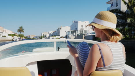 Always-Connected-Woman-With-A-Phone-In-His-Hand-On-A-Boat-Floats-On-The-Channel-The-Resort-Town-Of-E