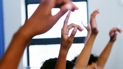 student raising hand in classroom