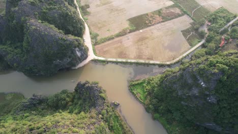 Fliegen-Sie-über-Gipfel-Und-Steile-Hänge-Von-Kalksteingebirgsketten-Und-Neigen-Sie-Sich-Bei-Sonnenuntergang-Auf-Den-Fluss-Ngo-Dong-In-Ninh-Binh-Vietnam