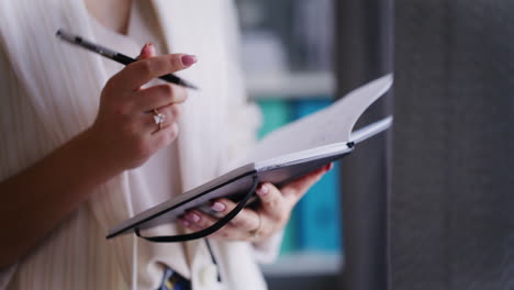 businesswoman writes meeting dates in notebook