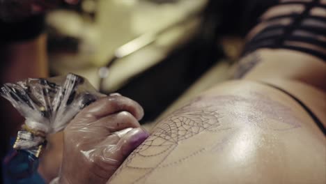 artista del tatuaje trabajando en un diseño de tela de araña tatuaje