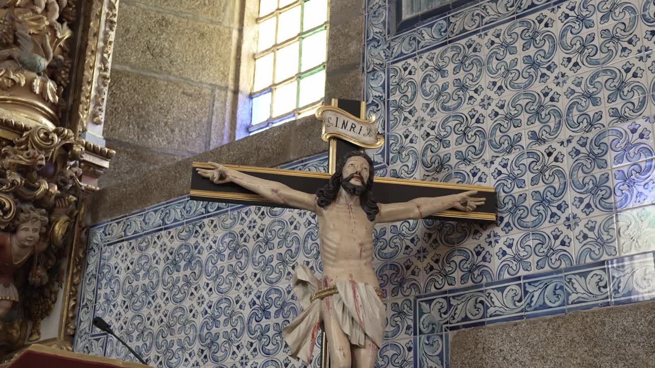 Crucifix sculpture against ornate blue and white azulejo tile background