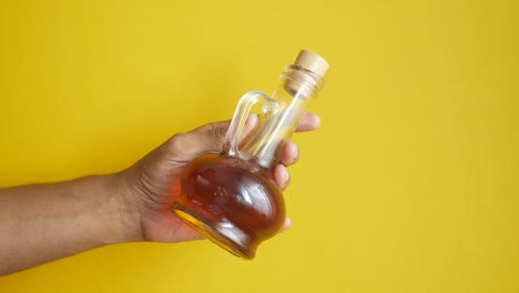 hand holding a small glass bottle of oil