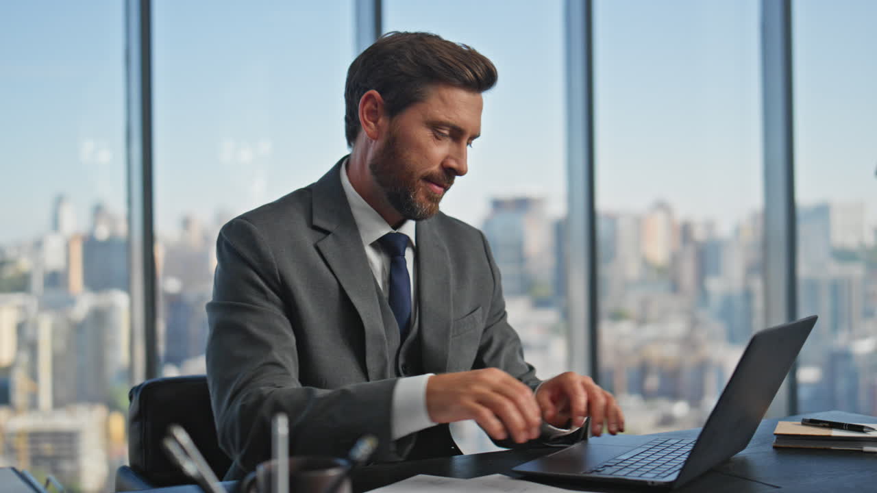 un uomo d'affari concentrato che guarda i documenti alla scrivania. un uomo sorridente e ispirato che scrive sul portatile.