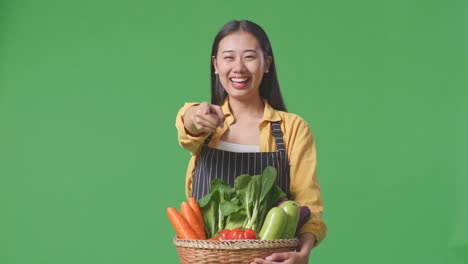 woman farmer holding basket of fresh vegetables