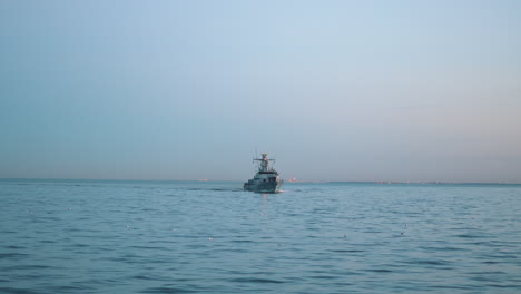 military ship sailing on the sea at the sunset