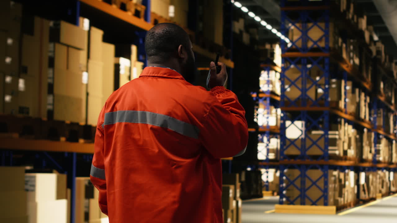 Lavoratore della logistica che comunica tramite un dispositivo walkie-talkie portatile