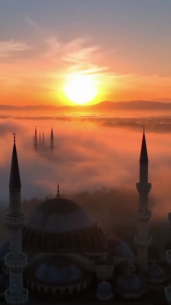 Maestosi minareti di moschea emergono dalla nebbia all'alba dorata